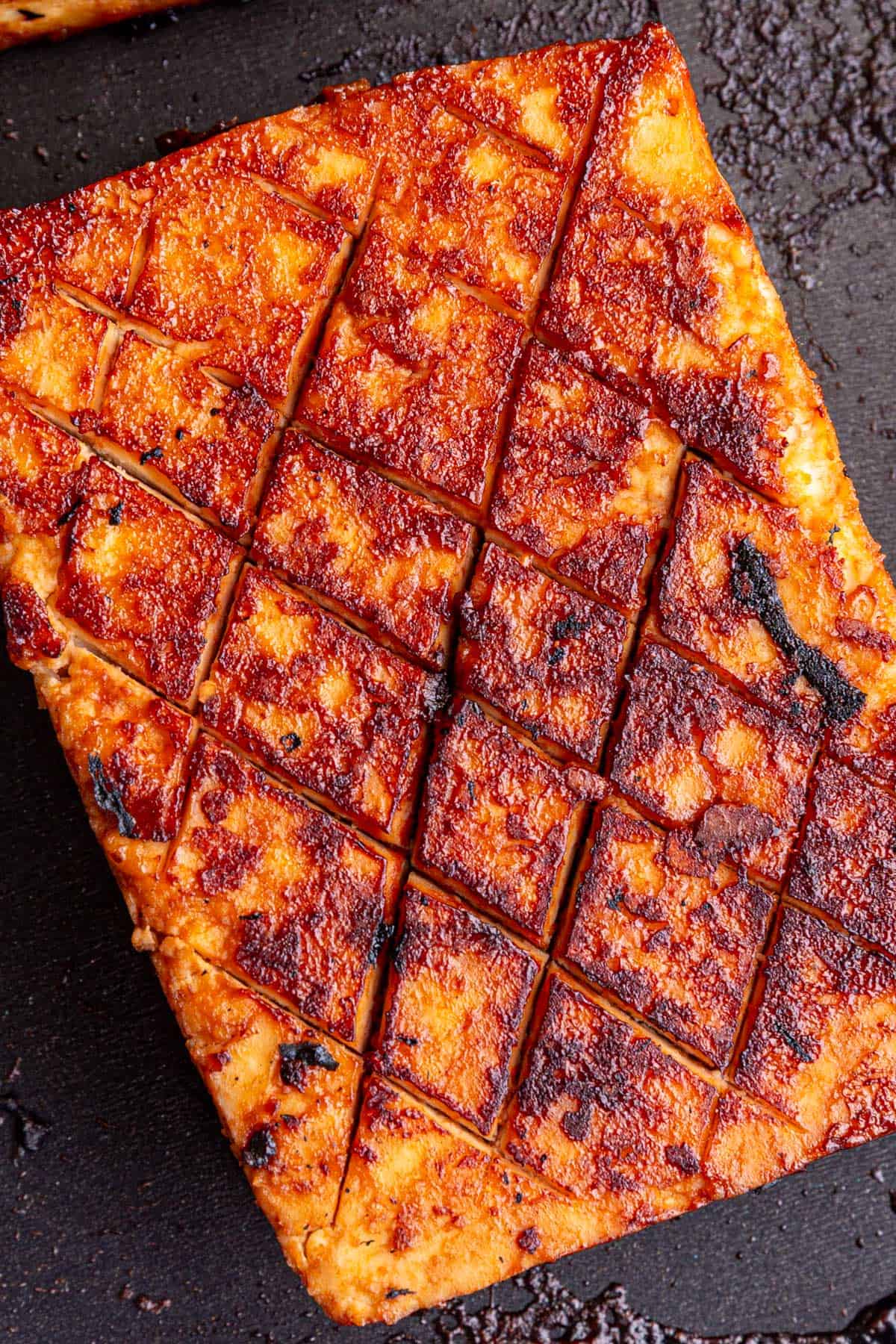 A close up view of the texture of a glazed tofu ham.