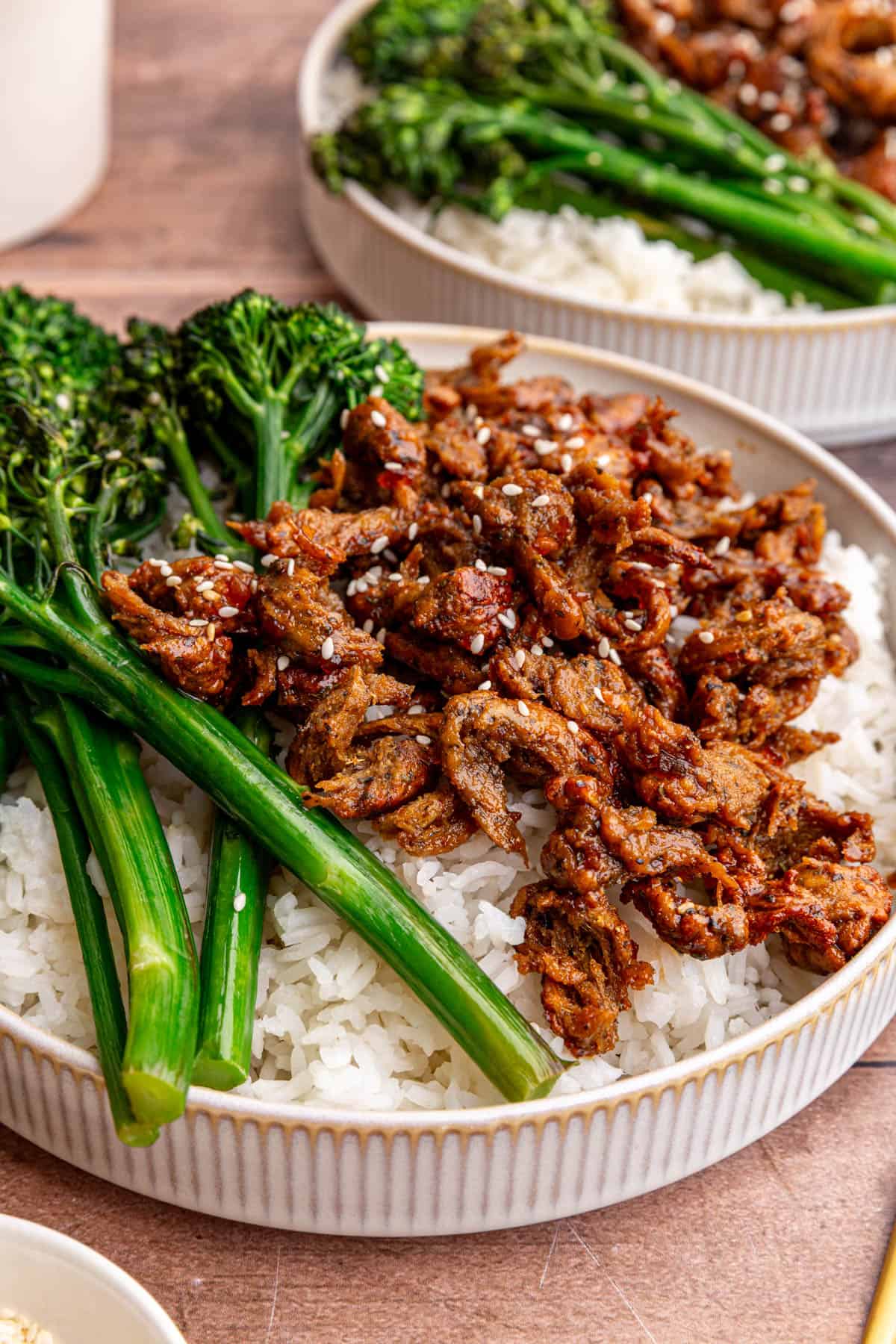 A bowl of vegan chicken teriyaki, garnished with sesame seeds.