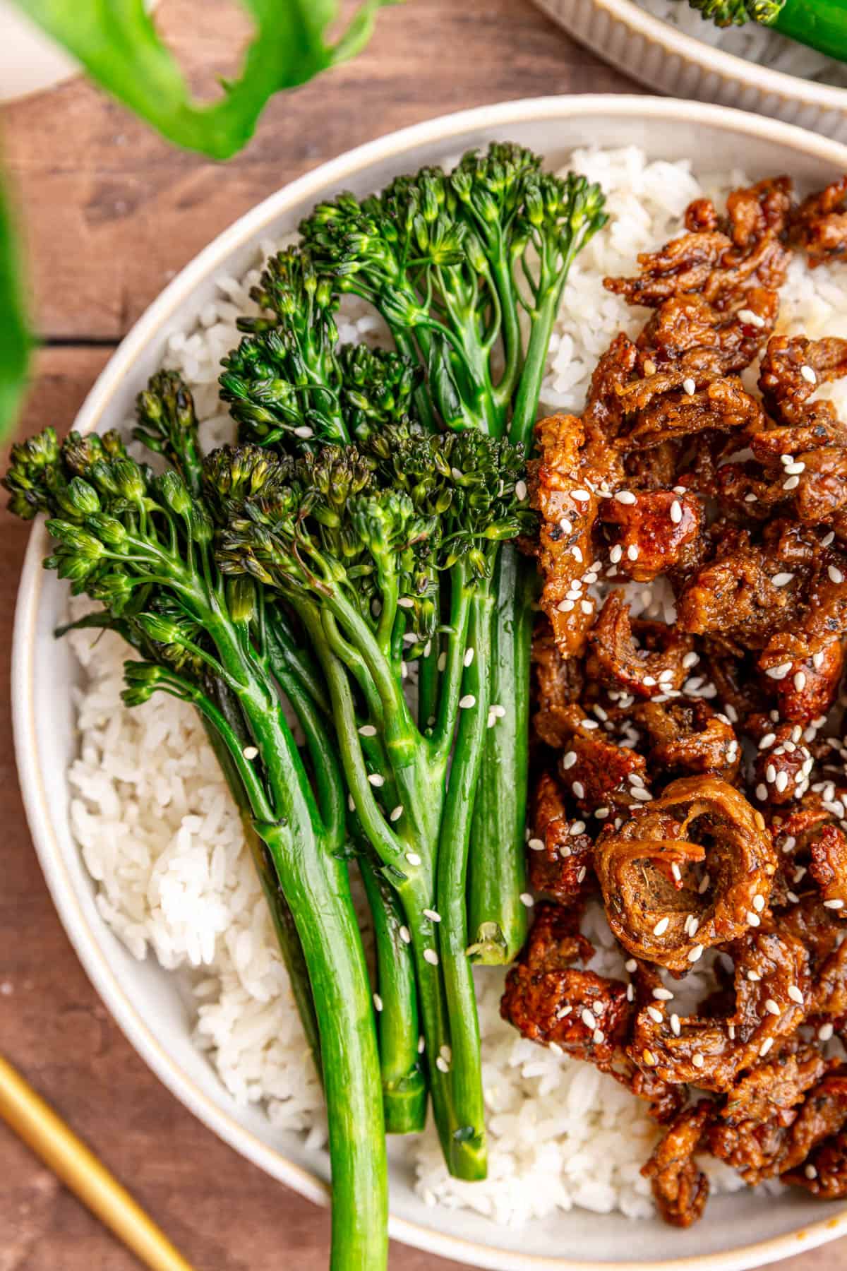 A close up view of the broccolini in a bowl of vegan chicken teriyaki.