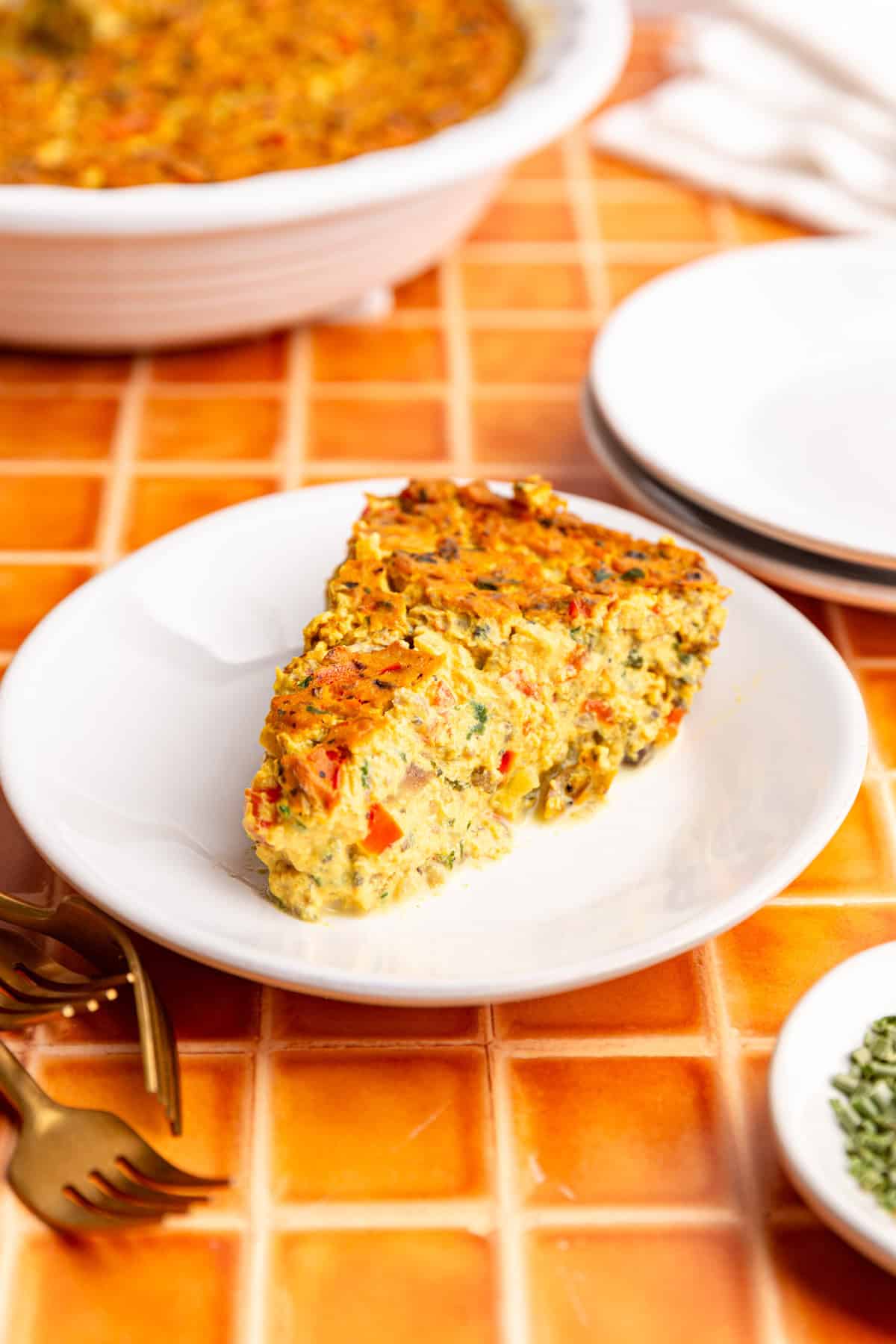 A slice of vegan frittata on a plate, ready to eat.