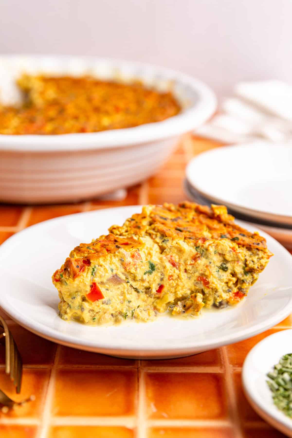 A slice of vegan frittata on a plate, ready to eat.