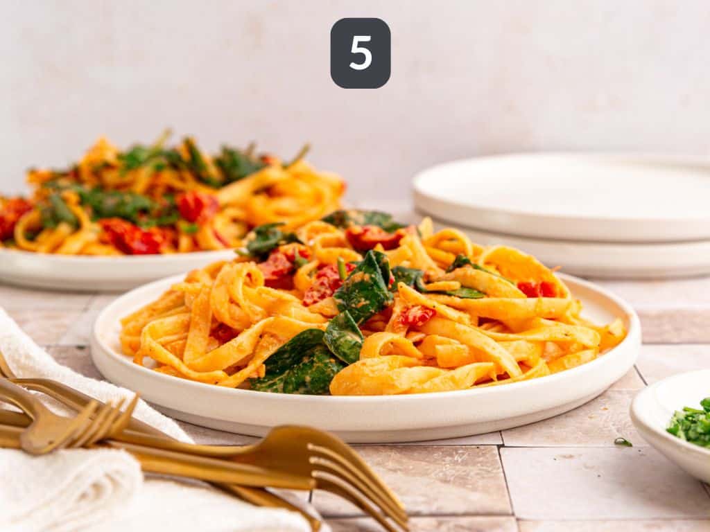 Vegan sundried tomato pasta step 5 - serve garnished with parsley.