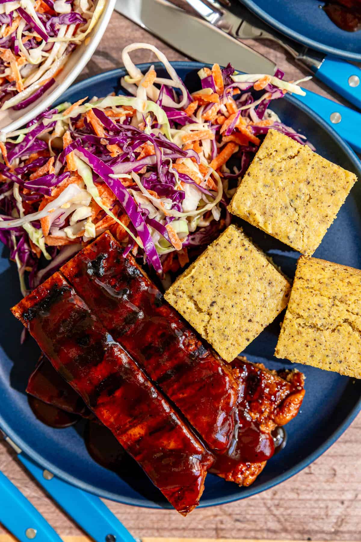 A plate of bbq seitan ribs, cornbread, and coleslaw.