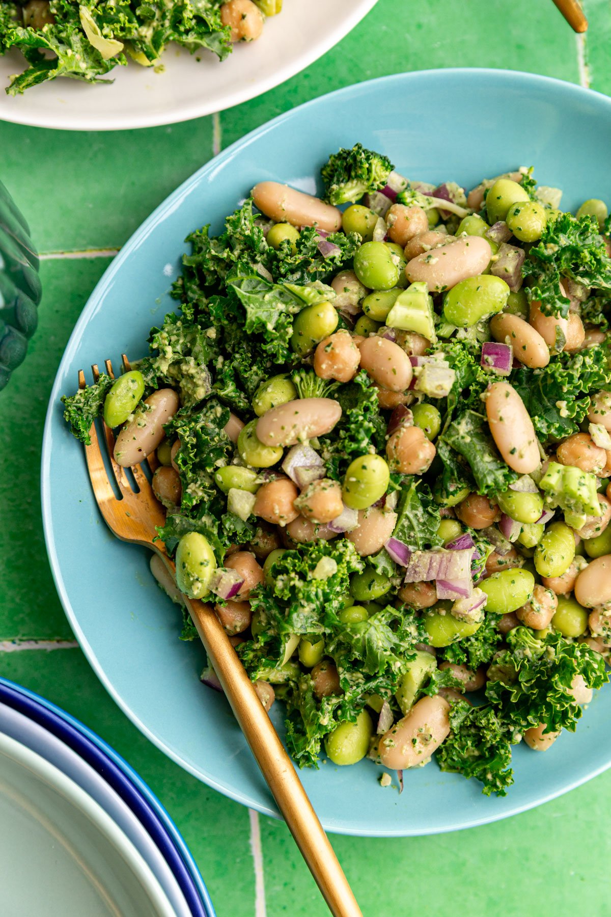A plate of pesto bean salad, with a fork, ready to eat.