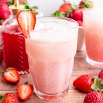 A glass of strawberry cream soda, with a strawberry for garnish.
