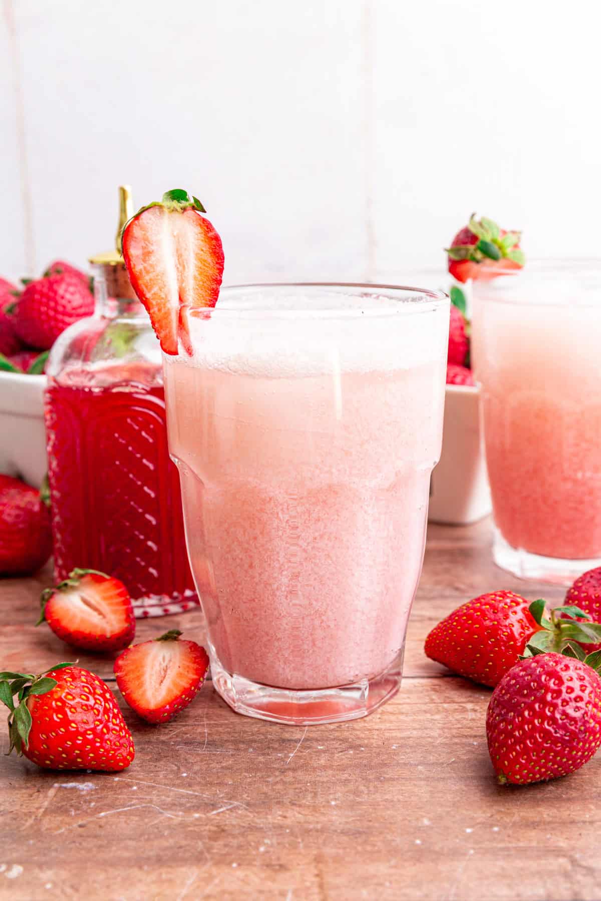 A glass of strawberry cream soda on a table.