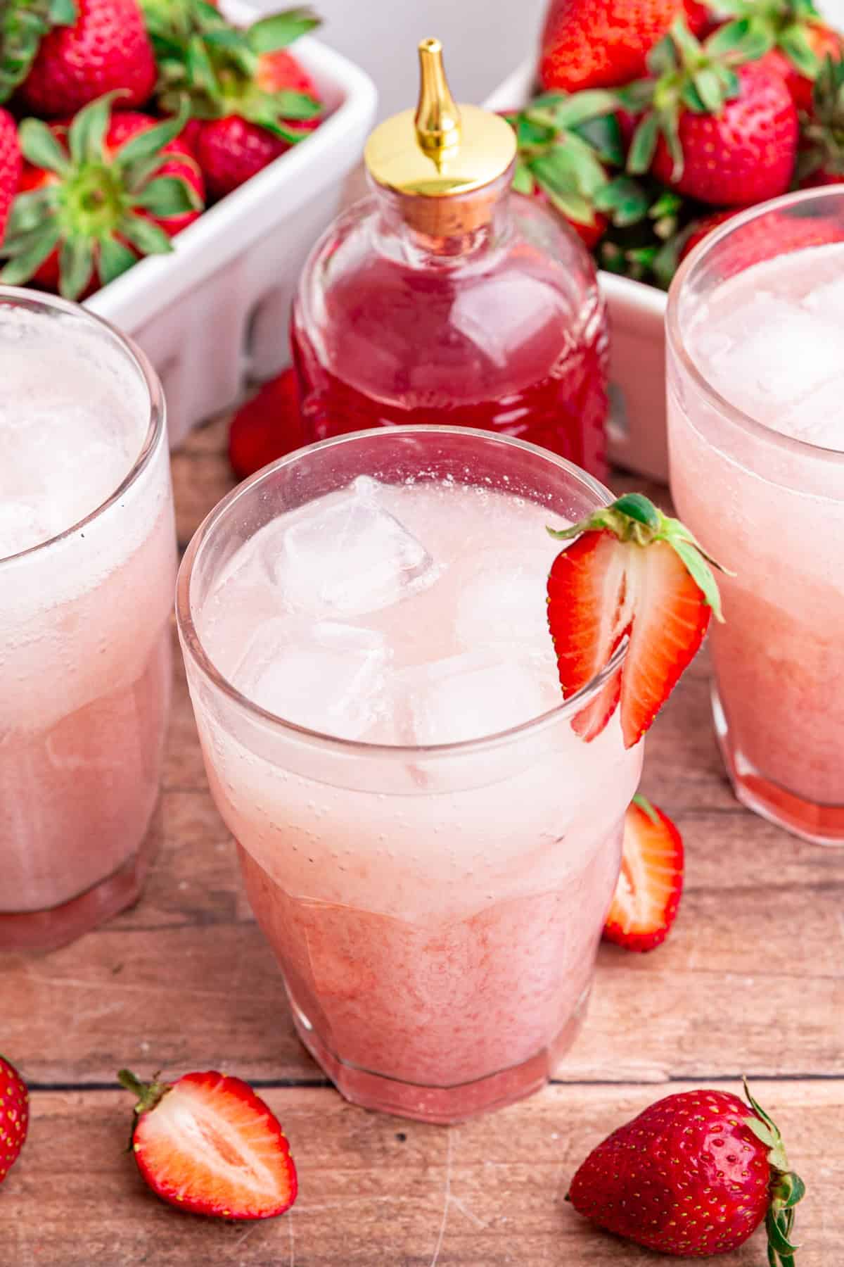 A glass of strawberry cream soda, with a strawberry for garnish.
