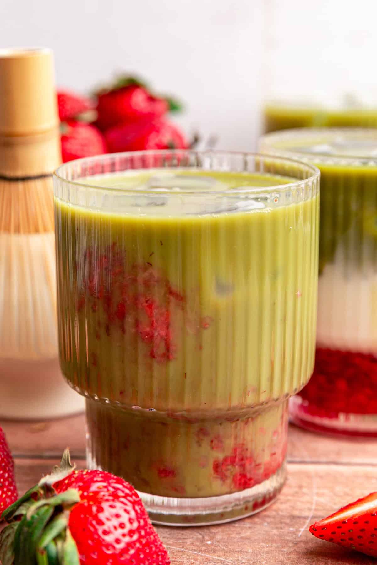 An iced oat milk strawberry matcha latte that has been mixed, so it's entirely green.