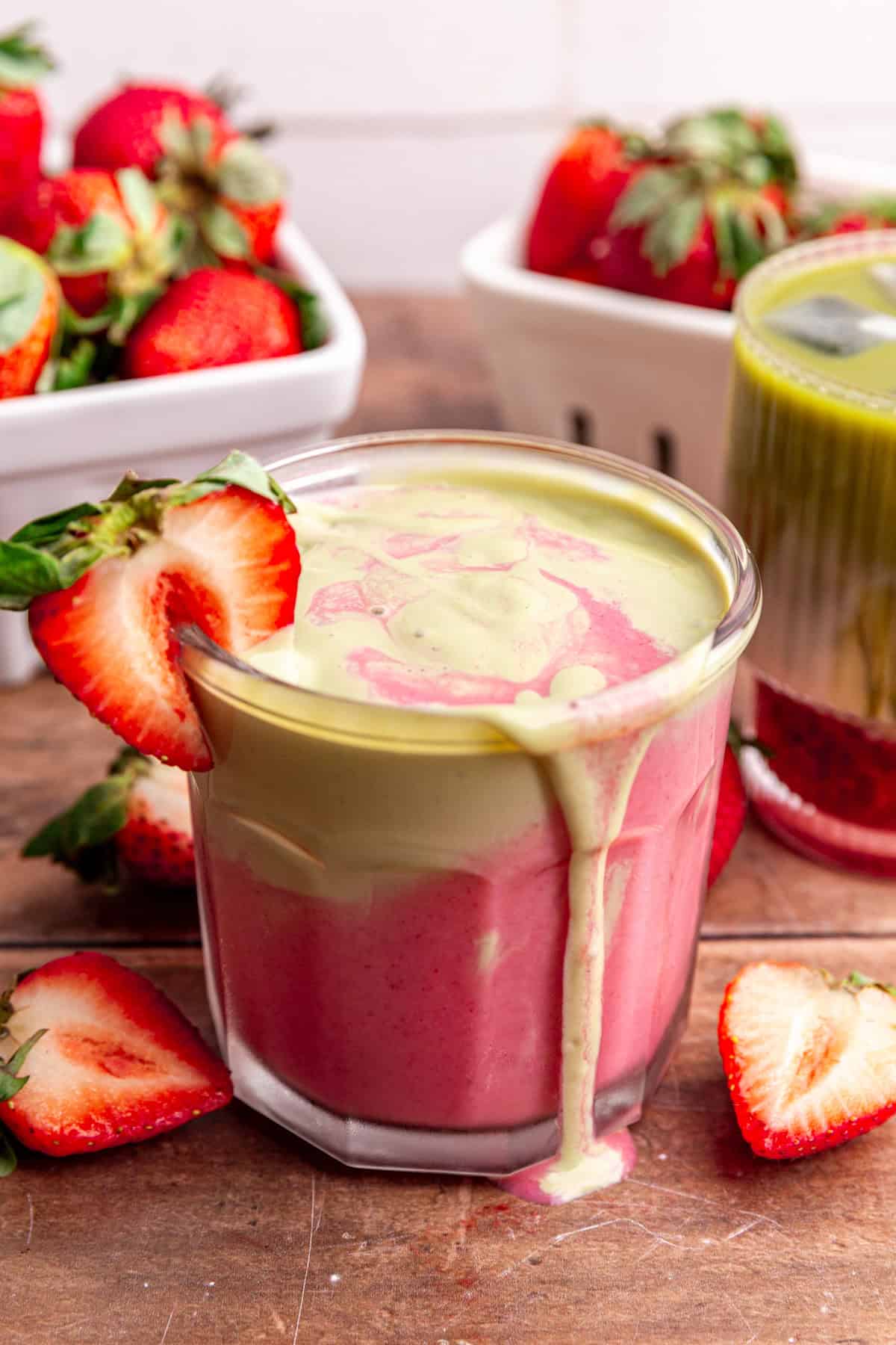 A strawberry matcha smoothie, overflowing onto the table.