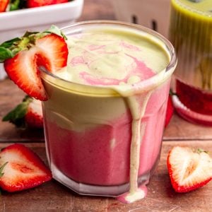 A strawberry matcha smoothie, overflowing onto the table.