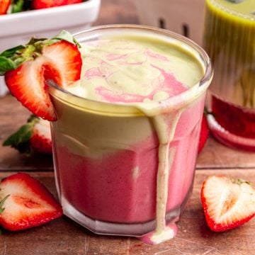 A strawberry matcha smoothie, overflowing onto the table.
