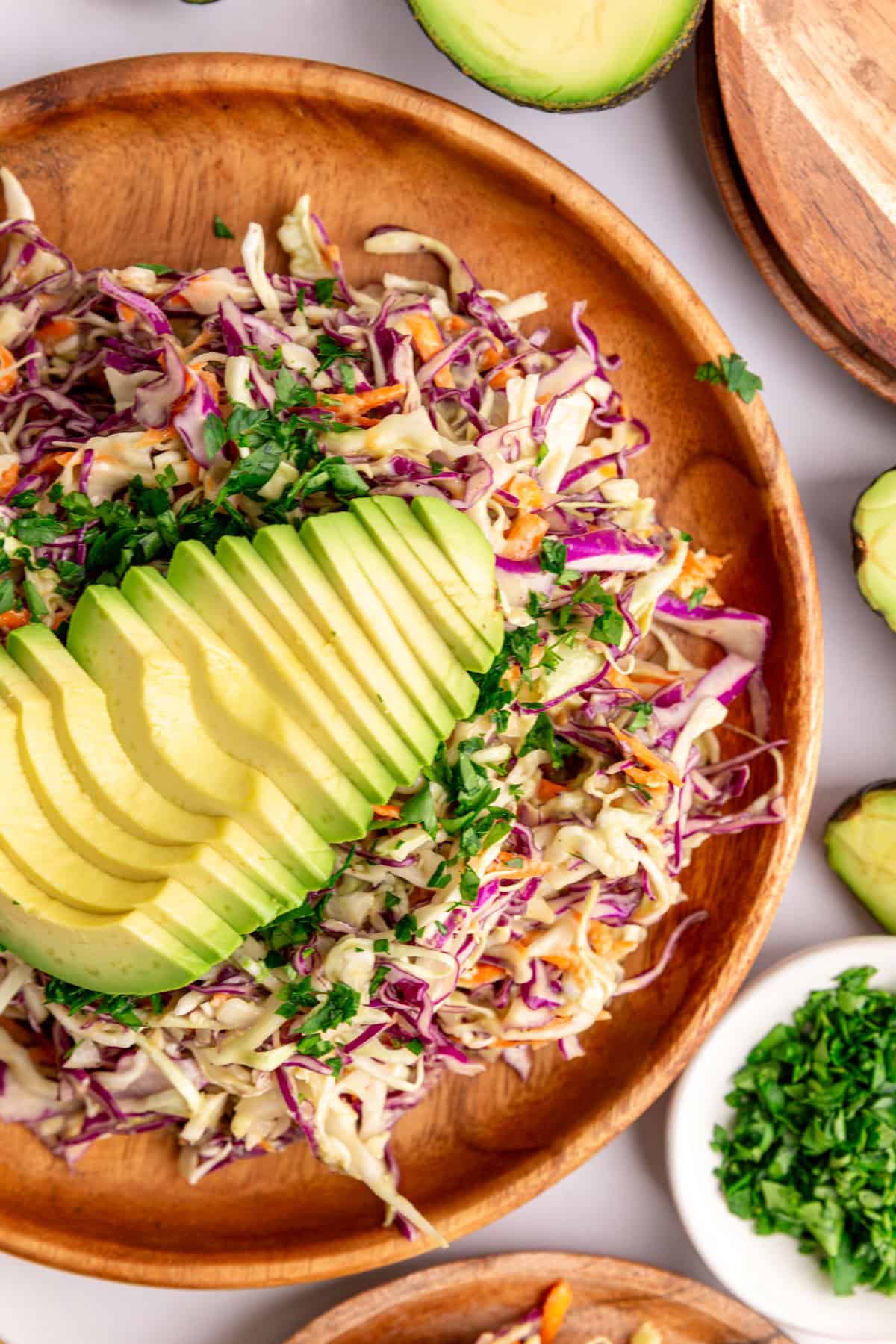 A plate of avocado slaw garnished with a sliced avocado.