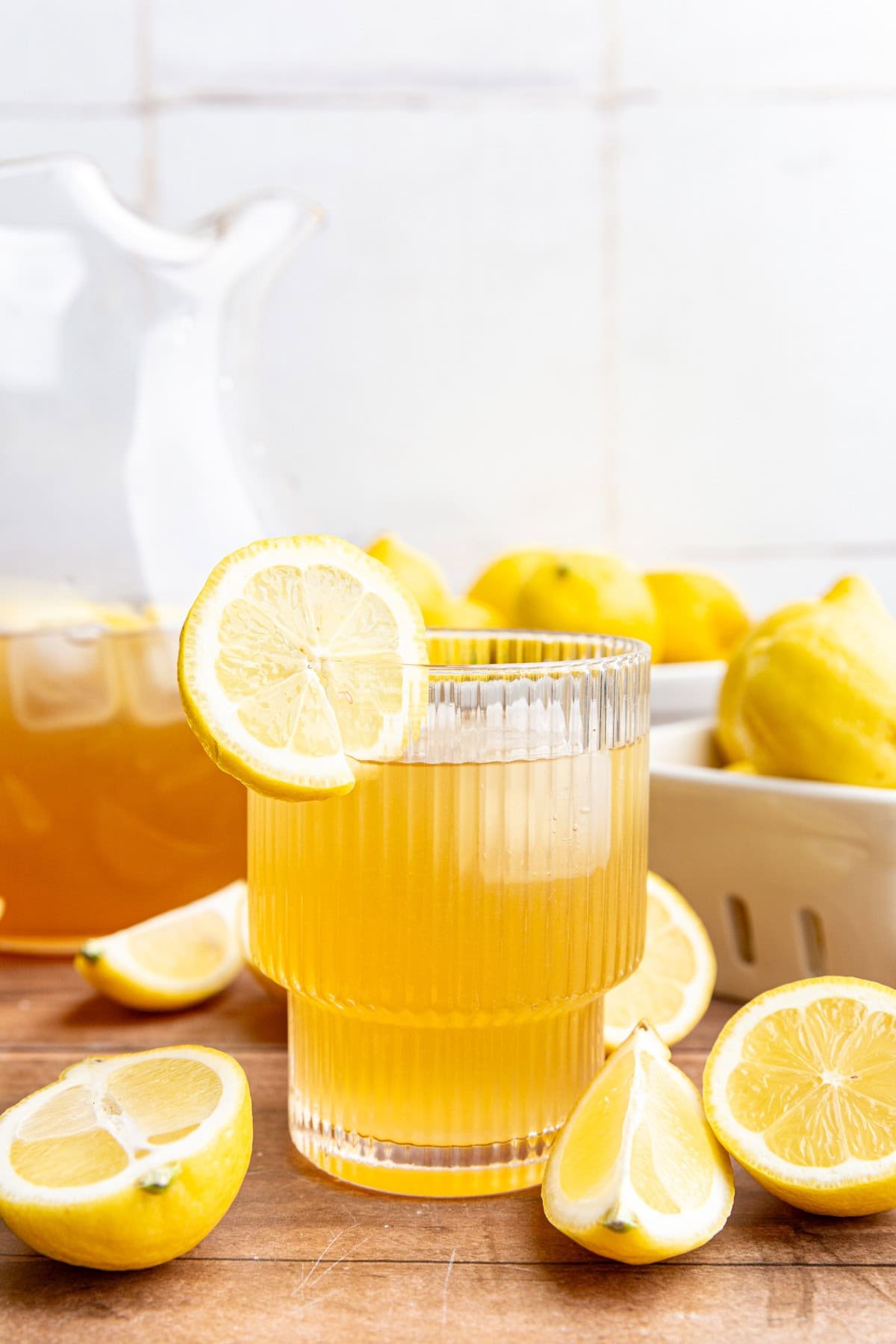 A glass of brown sugar lemonade with a lemon slice on the rim.