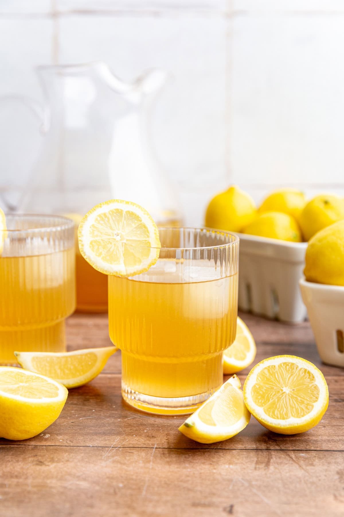 A glass of brown sugar lemonade with a lemon slice on the rim.
