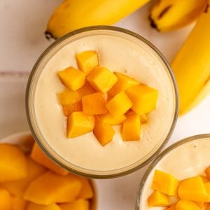 A top down view of a thick mango smoothie topped with mango chunks.
