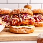 A vegan nashville hot chicken sandwich, with slaw, pickles, and mayo.