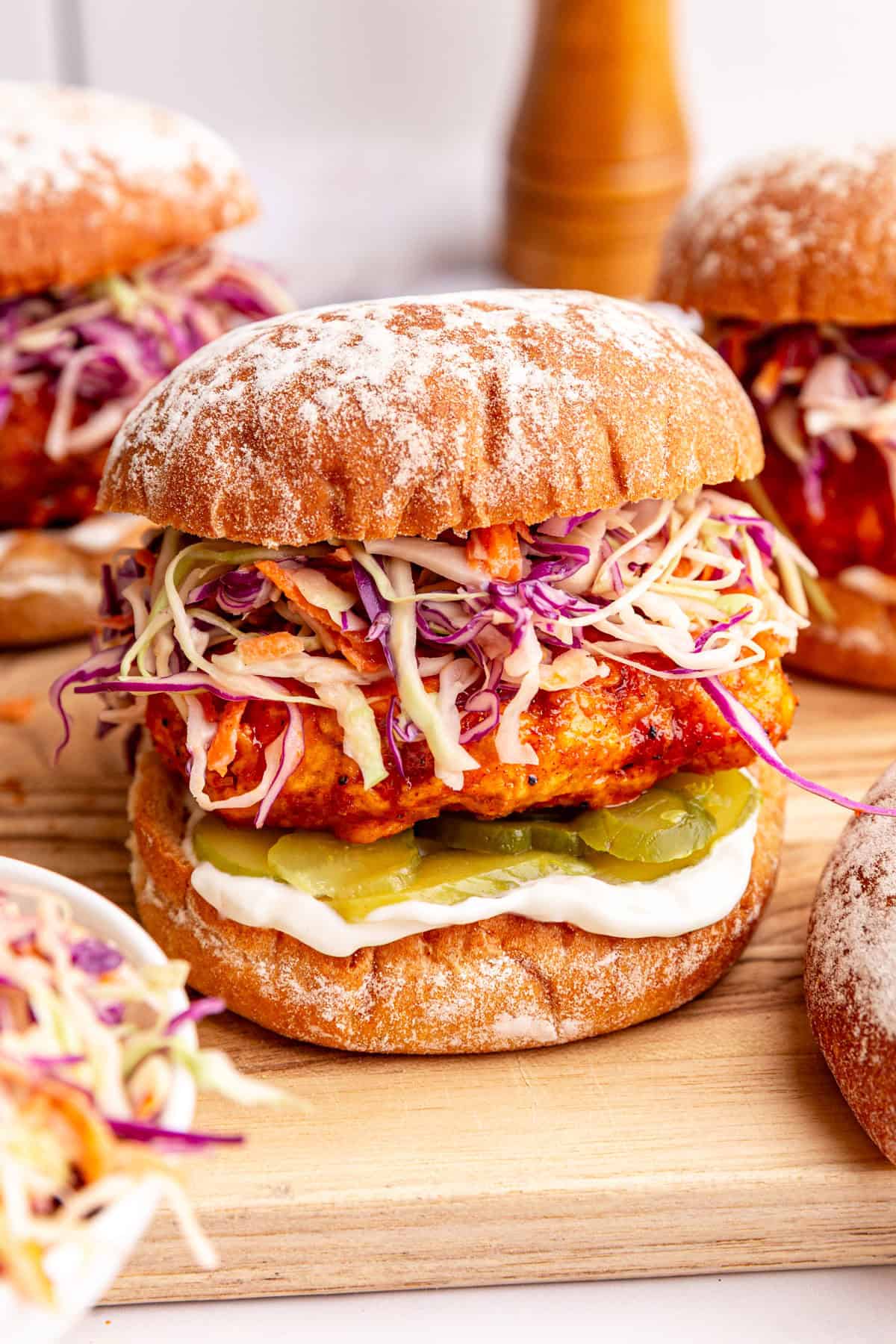 A hot chicken sandwich on a cutting board.