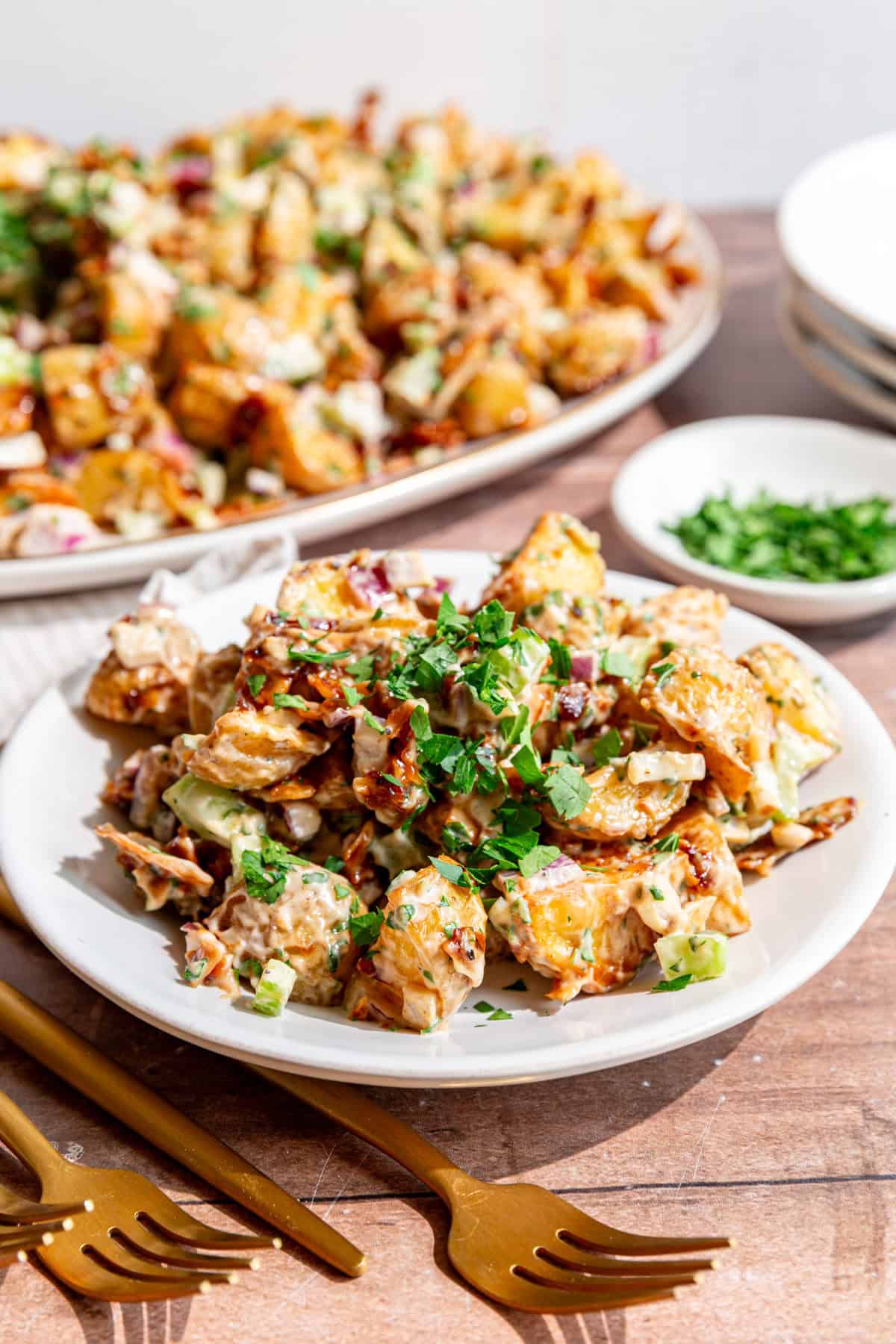 A plate of vegan roasted potato salad, with a fork, ready to eat.