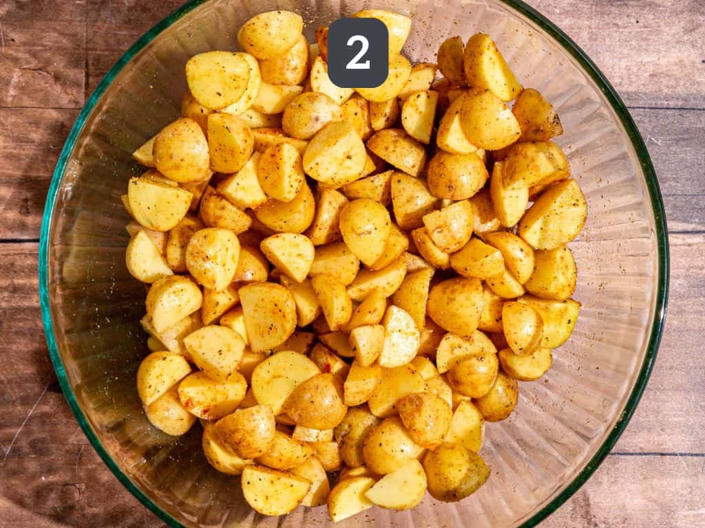 Vegan roasted potato salad step 2 - toss the potatoes, oil, and spices.