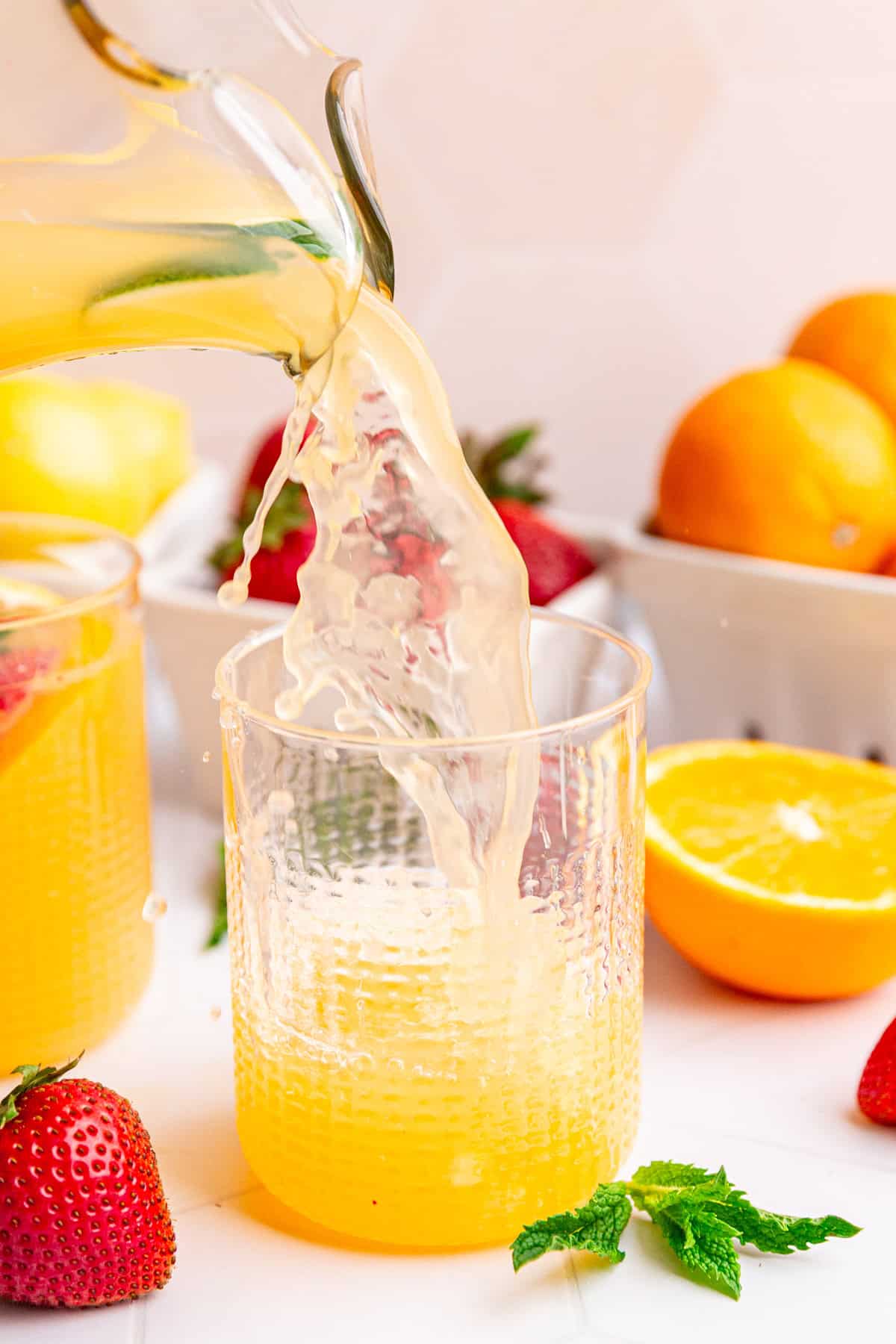 White sangria mocktail being poured into a glass.