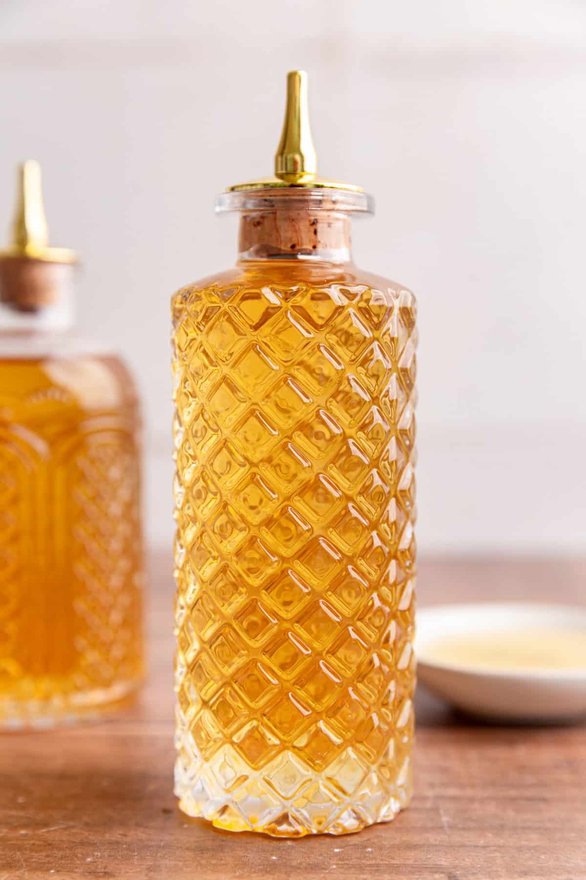 A bottle of agave simple syrup on a table.