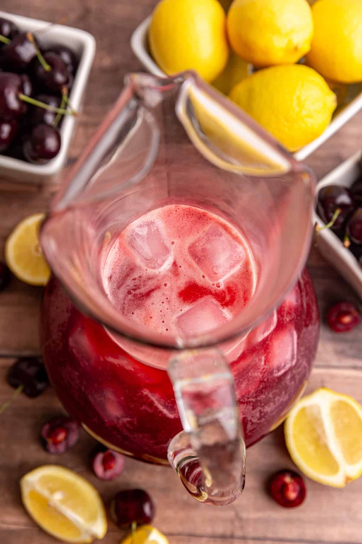 A top-down view of a pitcher of cherry lemonade.