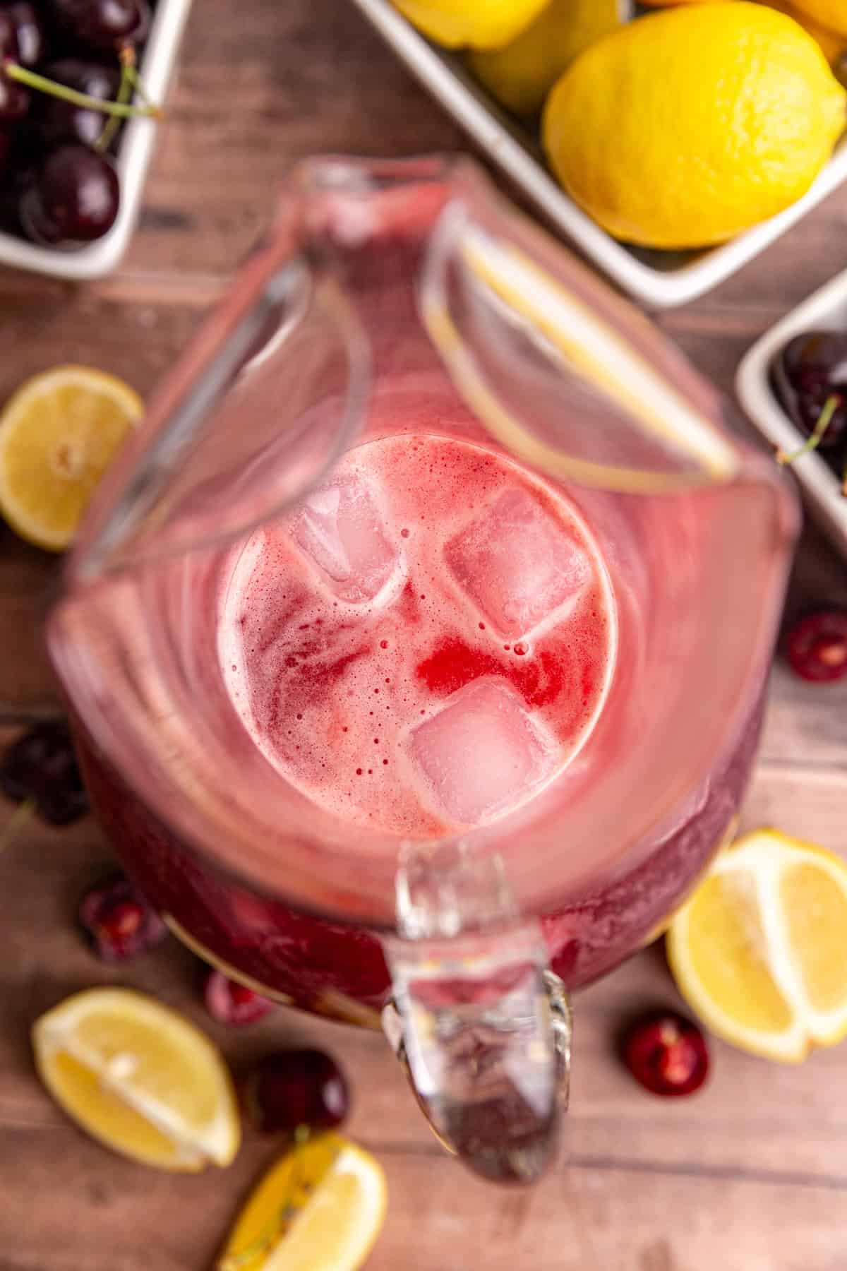 A top-down view of a pitcher of cherry lemonade.