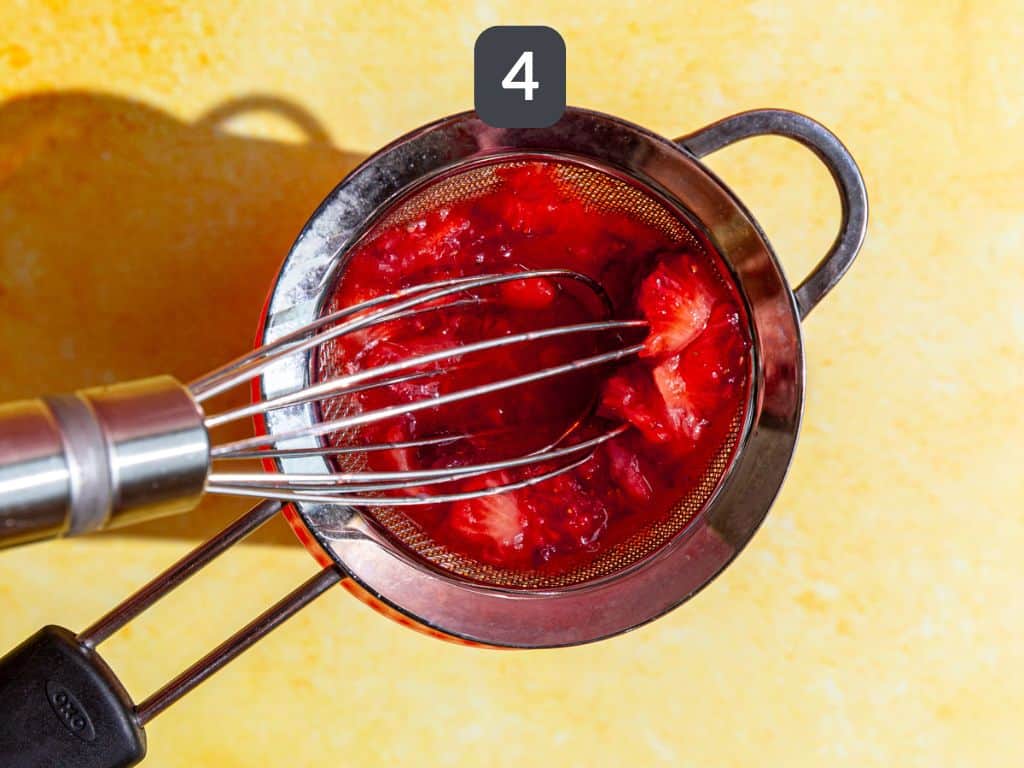 Strawberry Pink Lemonade Mocktail step 4 - strain the berry mixture over the ice.