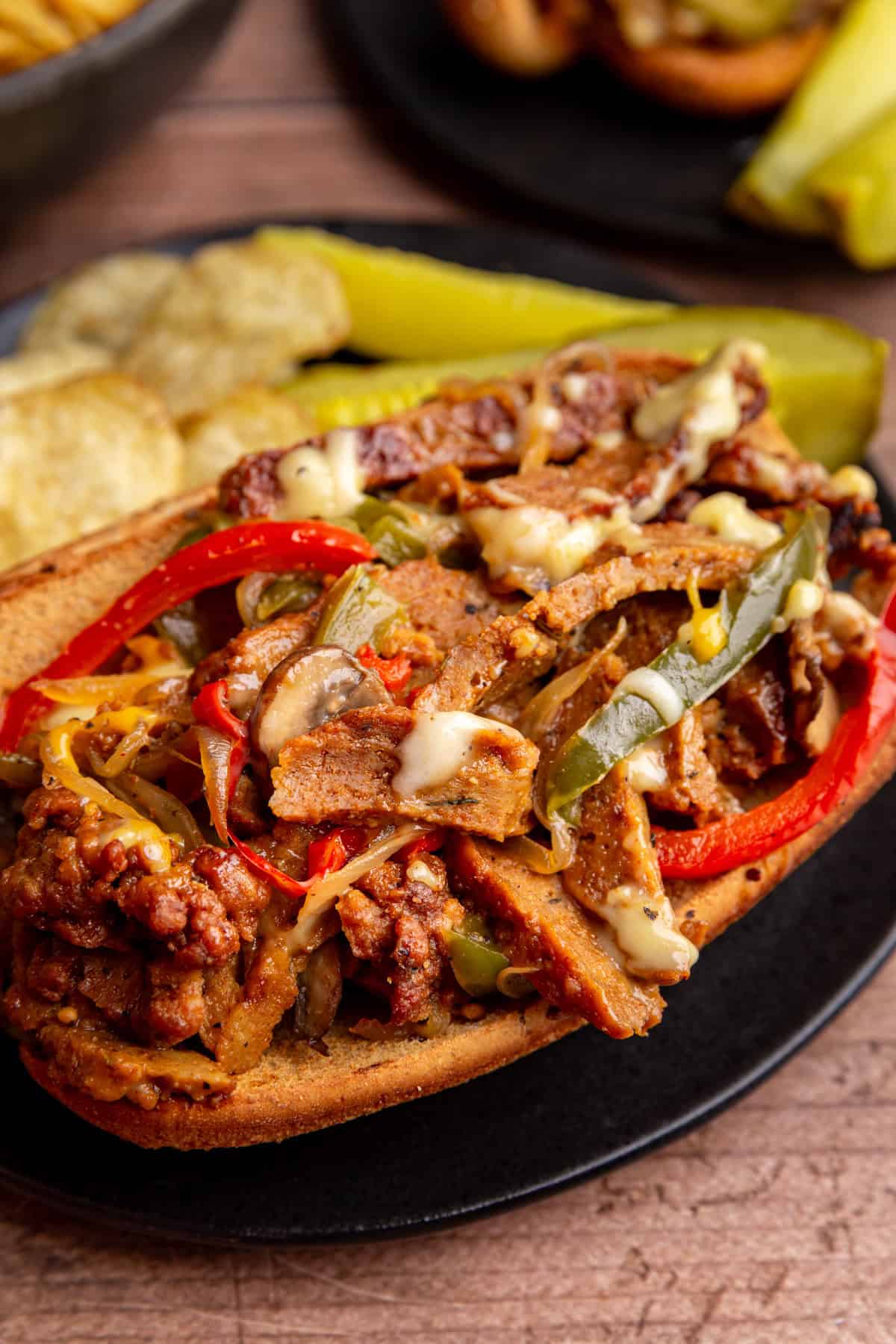 A close up view of a loaded, cheesy, vegan Philly cheesesteak.
