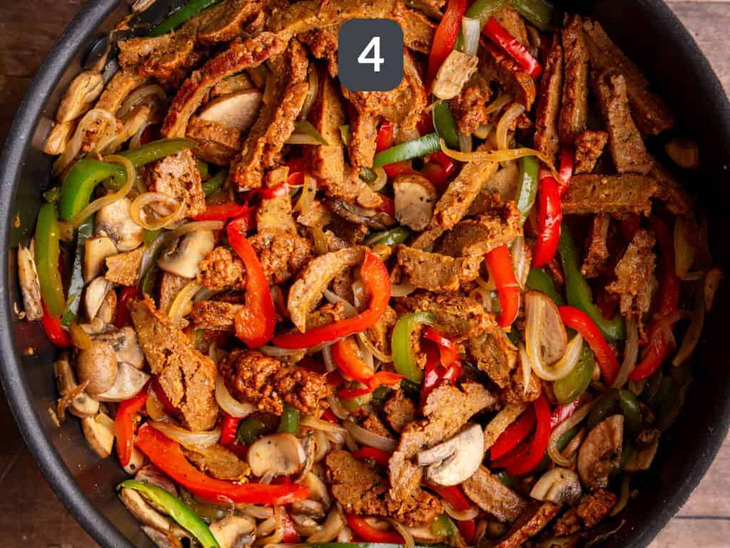 Vegan Philly Cheesesteak Step 4 - add the seitan steaks and toss.