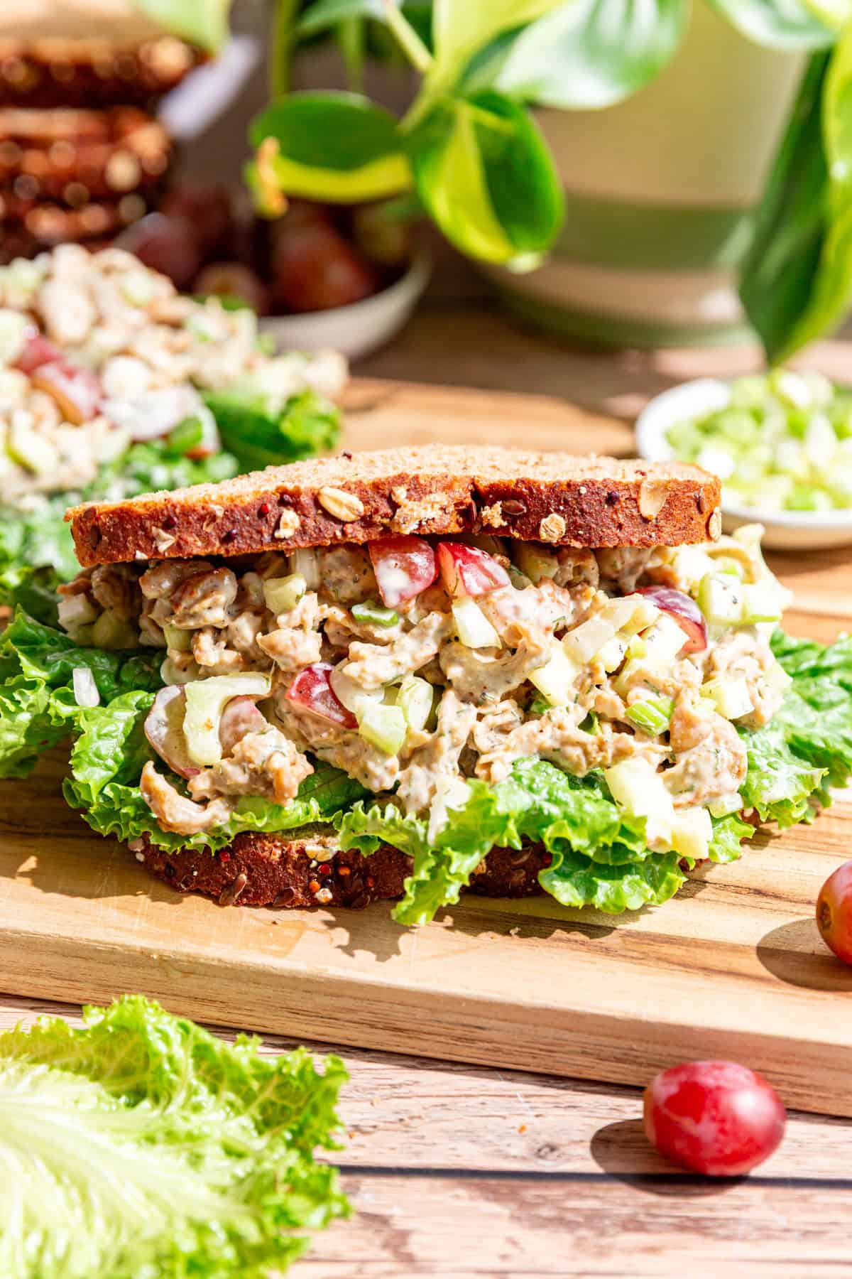 A Vegan Protein Chicken Salad sandwich on a cutting board.