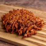 A bath of seitan pastrami sliced on a cutting board.