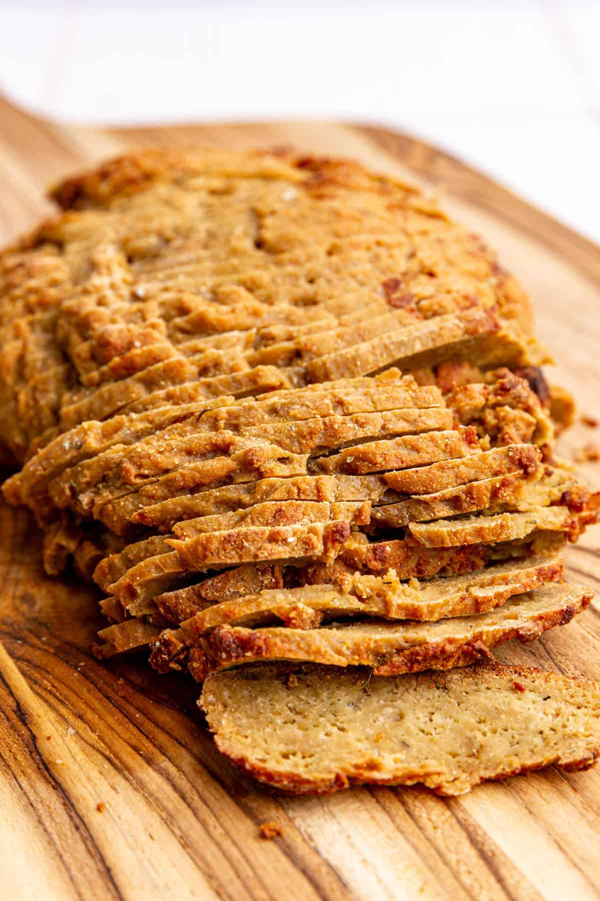 Vegan turkey deli meat sliced on a cutting board
