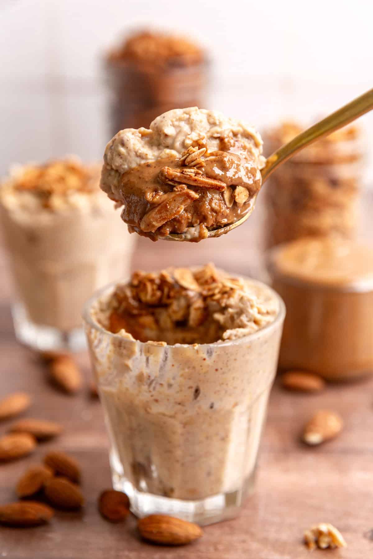 A spoon taking a scoop of almond butter overnight oats.