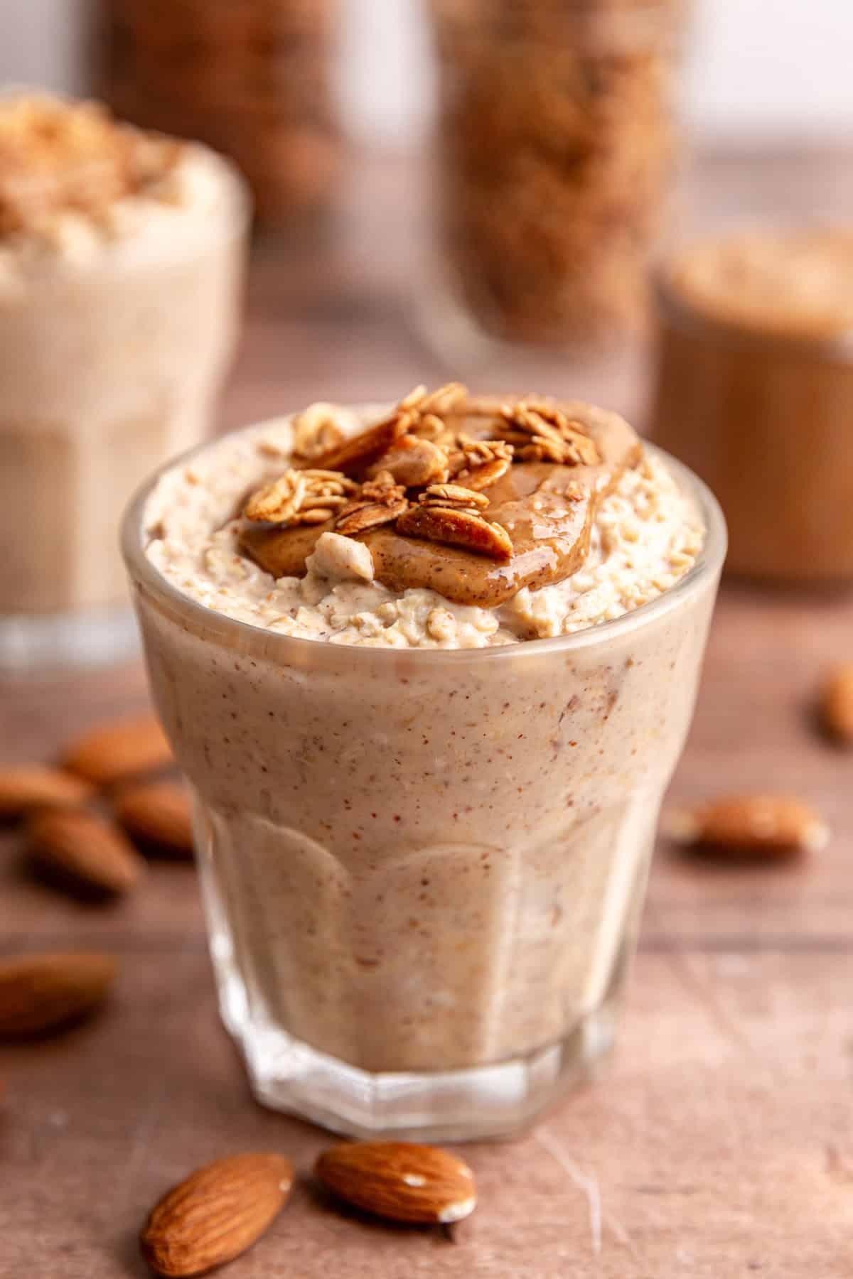 A jar of almond butter overnight oats, topped with almond butter and vanilla almond granola.