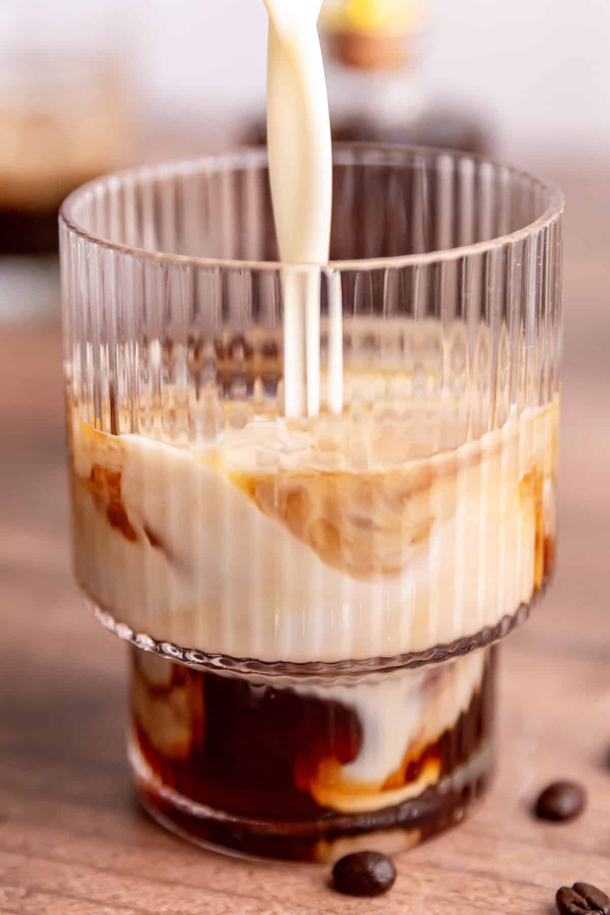 Milk being poured into an iced Brown Sugar Oat Milk Latte.