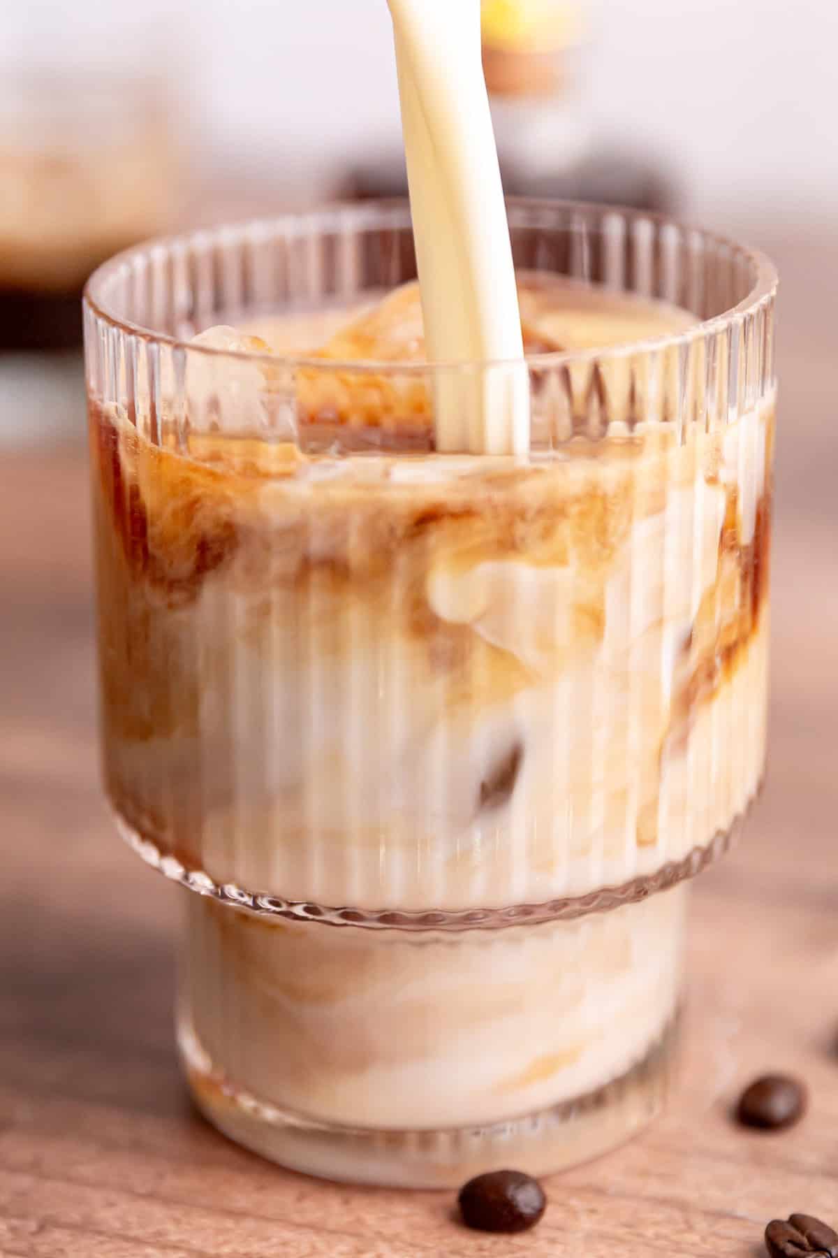 Milk being poured into an iced Brown Sugar Oat Milk Latte.