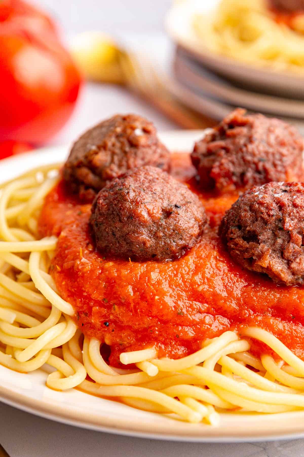 A plate of spaghetti and meatballs with roasted tomato pasta sauce.