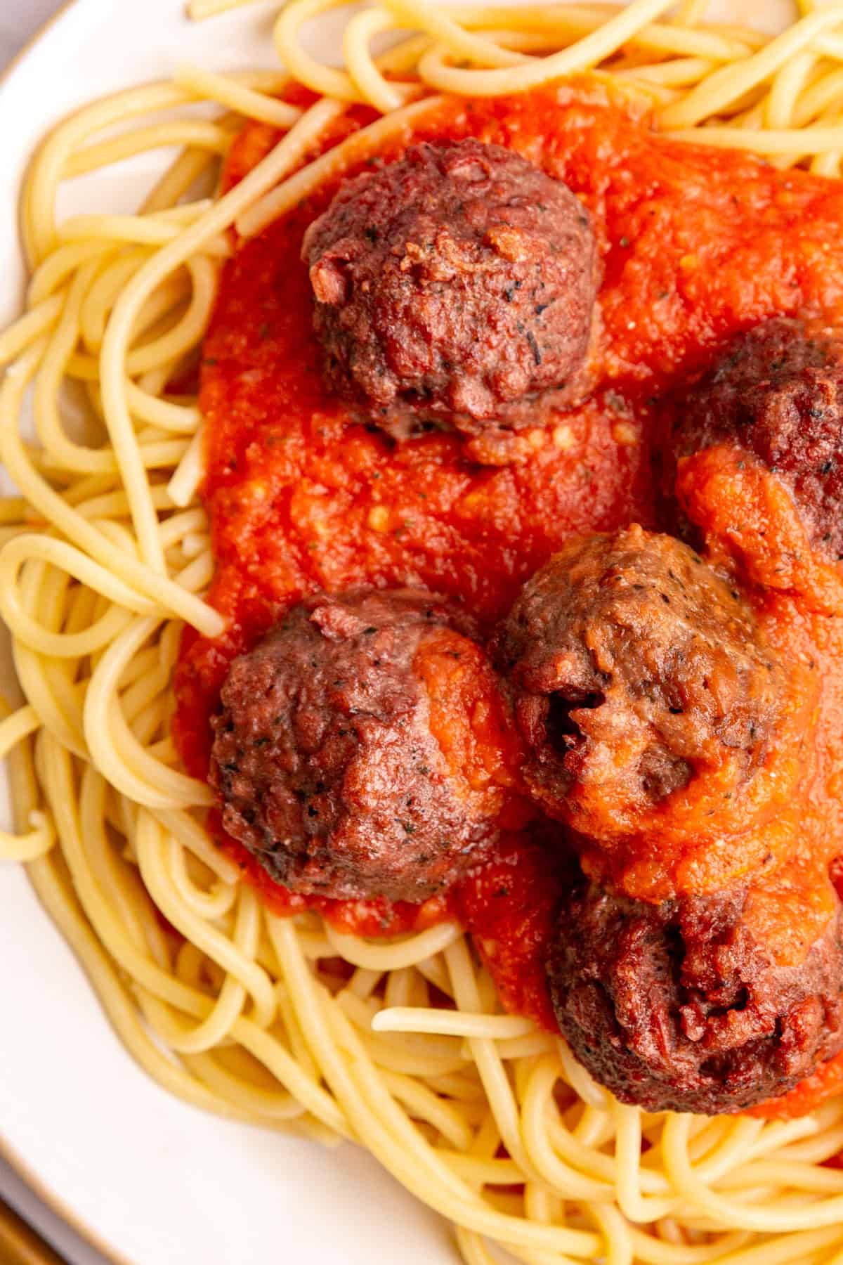 A plate of spaghetti and meatballs with roasted tomato pasta sauce.