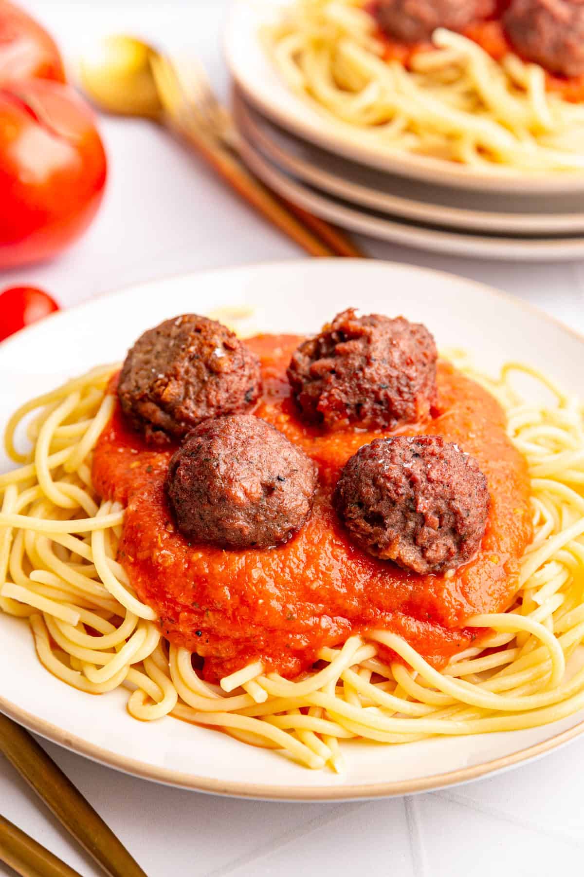 A plate of spaghetti and meatballs with roasted tomato pasta sauce.