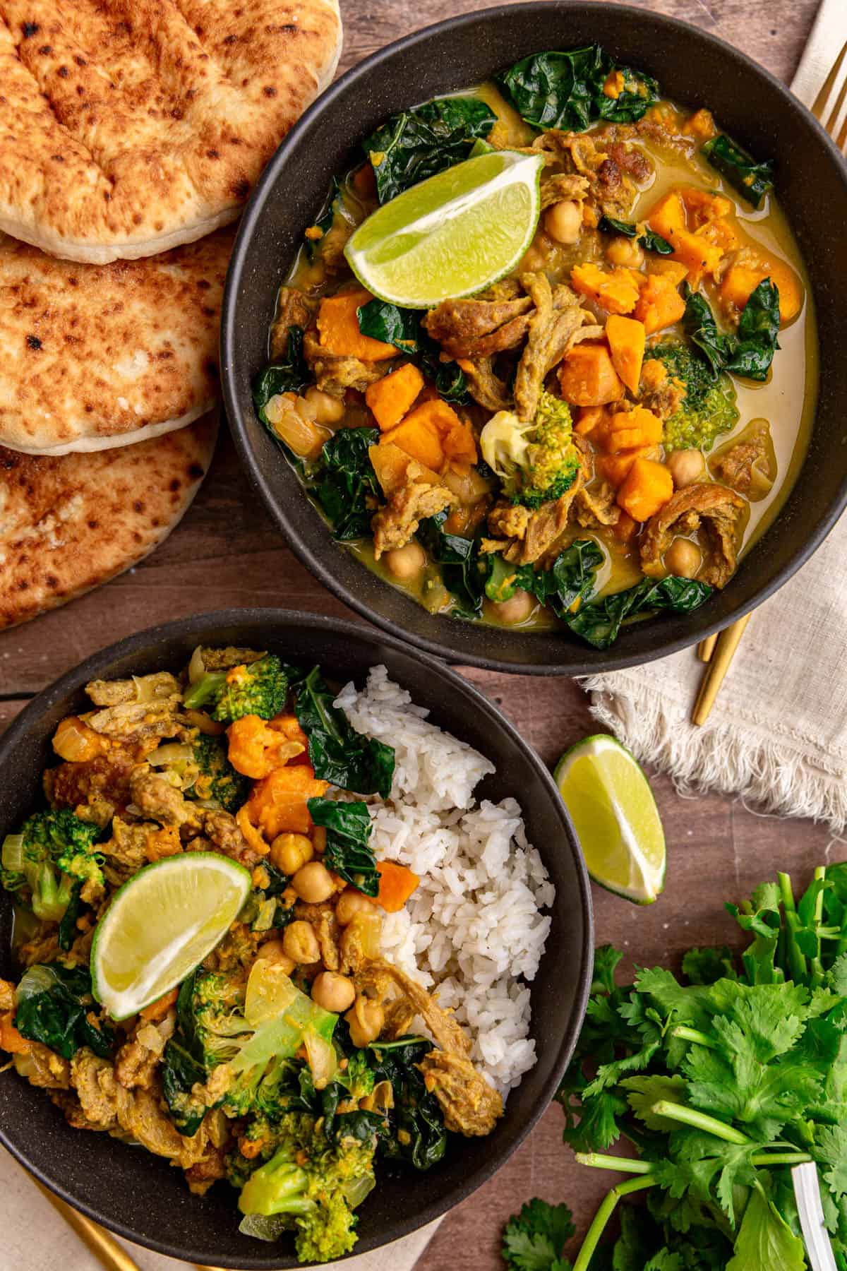 Two bowls of seitan curry, served with pita.