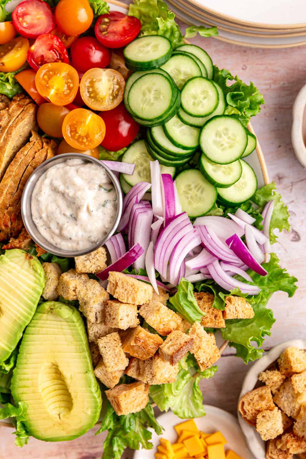 A close up view of the chefs salad, to see the tomatoes, cucumber, onions, and croutons.