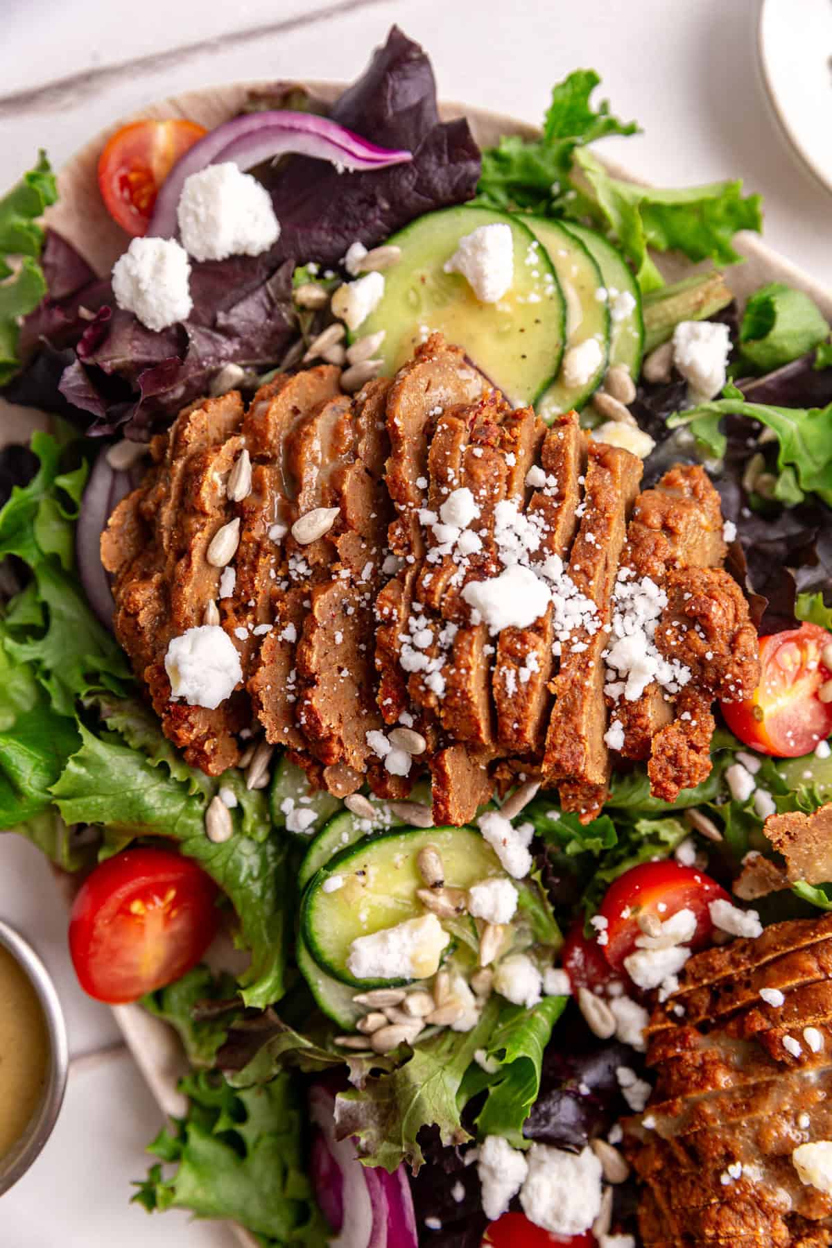 A close up view of the texture of the seitan steak on a vegan steak salad.