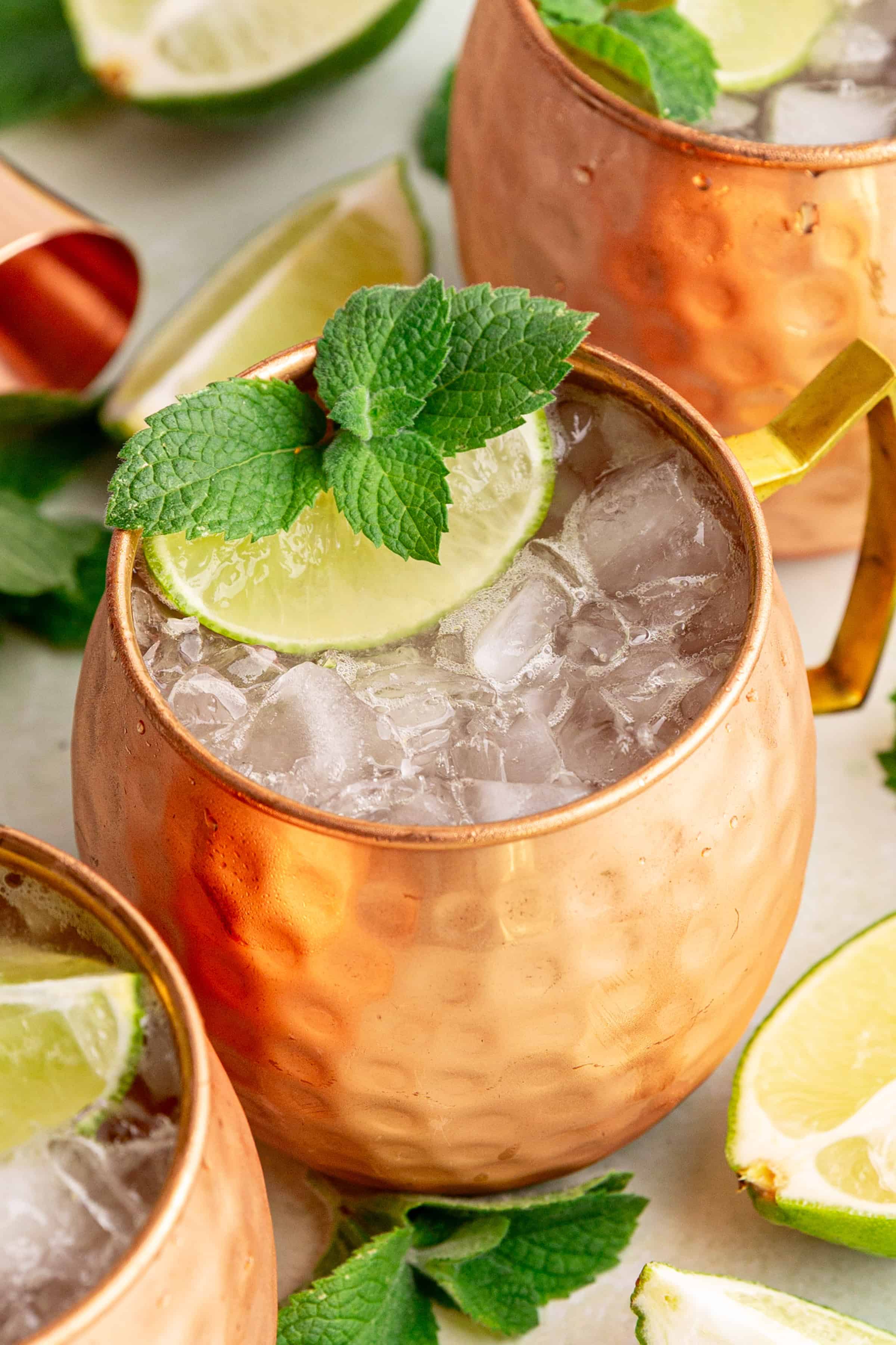 A Moscow Mule Mocktail in a mule glass, garnished with mint and a lime wedge.
