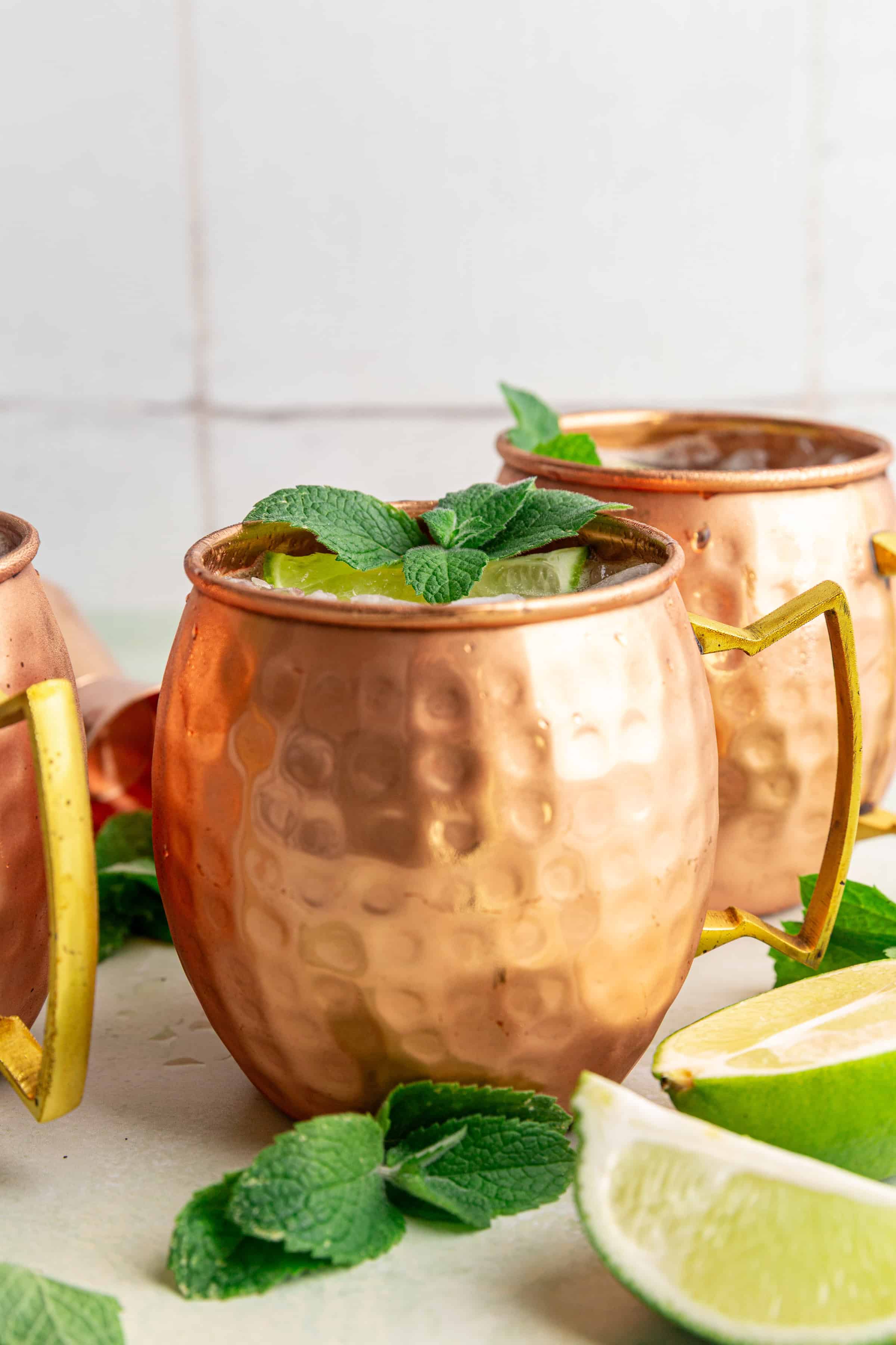A Moscow Mule Mocktail in a mule glass, garnished with mint and a lime wedge.