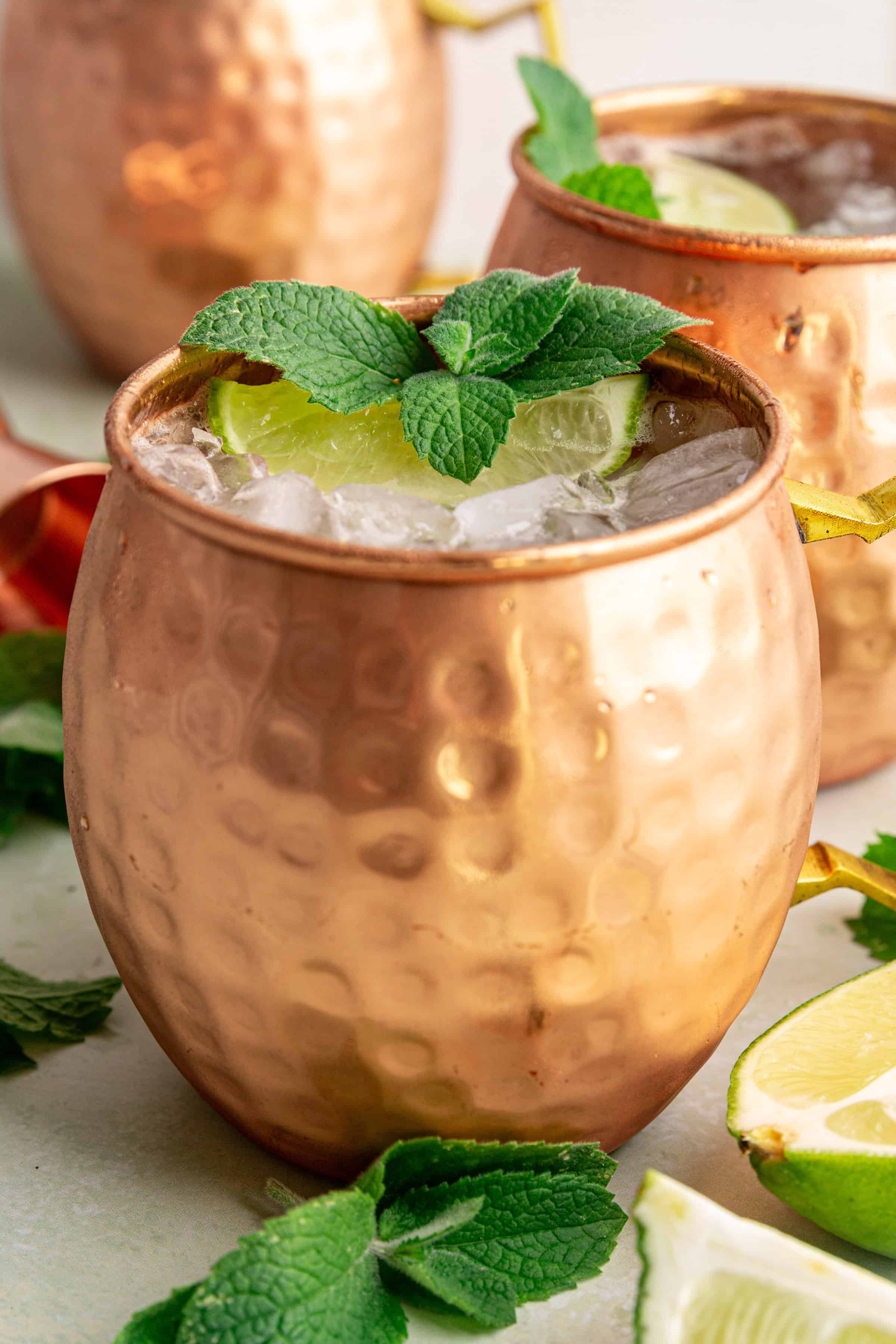 A Moscow Mule Mocktail in a mule glass, garnished with mint and a lime wedge.