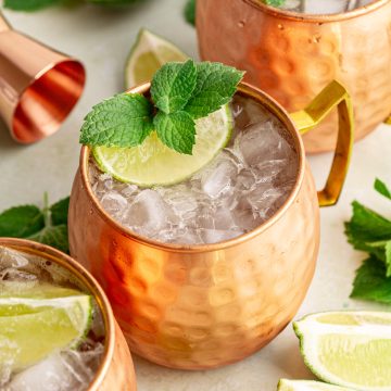 A Moscow Mule Mocktail in a mule glass, garnished with mint and a lime wedge.