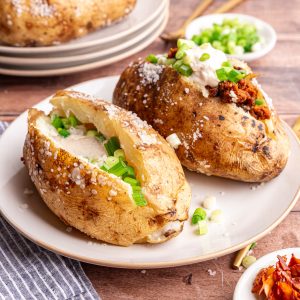 A plate of two loaded vegan baked potatoes.