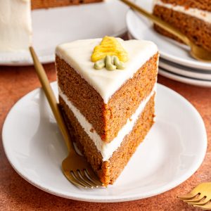 A slice of Vegan Carrot Cake, on a plate with a fork, ready to serve.