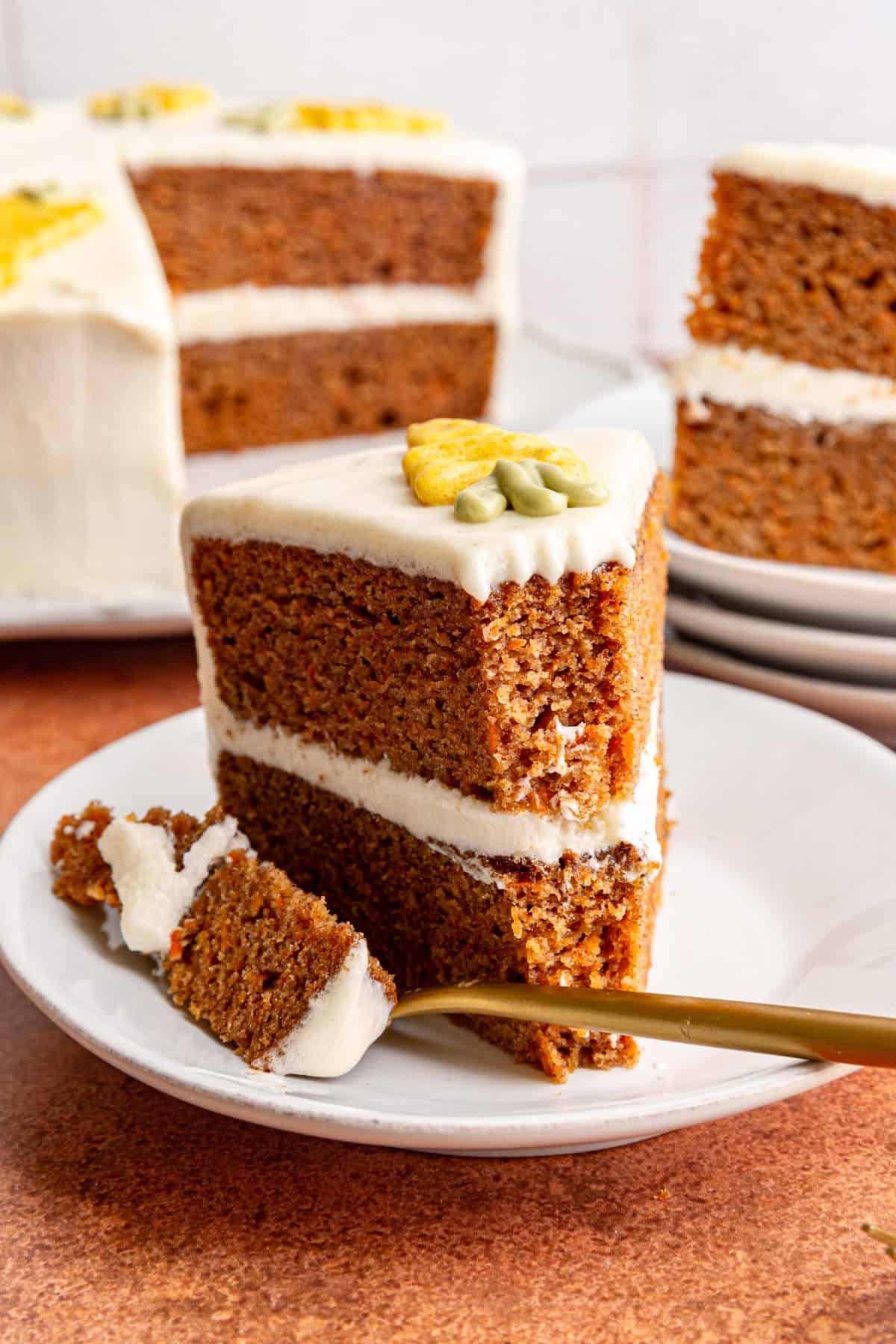 A slice of Vegan Carrot Cake with a bite taken out.